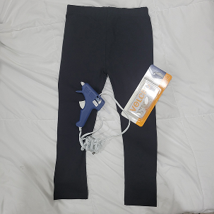 With these tests completed, I was able to determine that the velcro method was the most effective for creating a secure and adjustable resistance band. Here I have documented the next set of materials I gathered, which were a children's set of leggings made of cotton, some hot glue that I didn't end up using, and the velcro again.